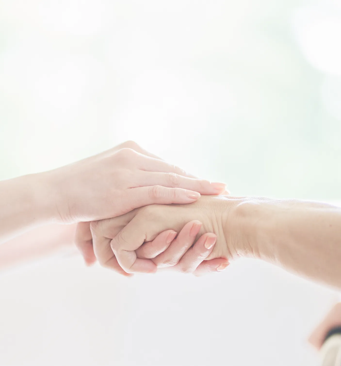 老人の手と介護士の手